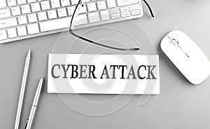 CYBER ATTACK text on paper with keyboard on grey background