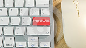 Cyber bullying red button on silver keyboard