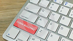 Cyber bullying red button on silver keyboard