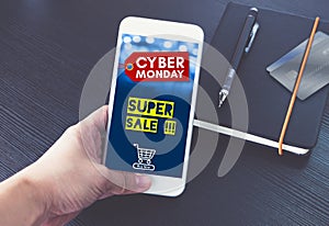 Cyber monday sale tag with shopping cart on mobile screen,Hand h
