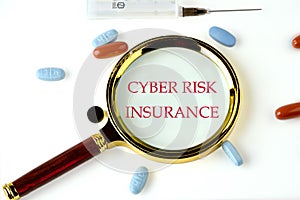 Cyber Risk Insurance text through a magnifying glass on a white background with pills and vitamins lying next to it