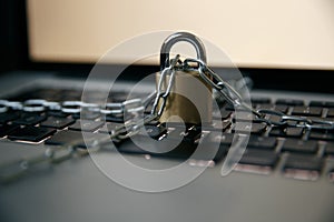 Cyber safety concept, locked chain on laptop computer keyboard photo