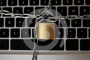 Cyber safety concept, locked and key on laptop computer keyboard ,key to unlock before green background.Key and Lock on photo