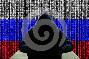 Cyber threat from Russia. Russian hacker at the computer, on a background of binary code, the colors of the flag of Russia. DDoS