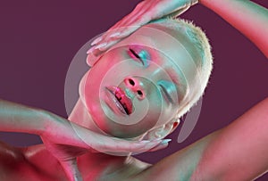 Cyberpunk, neon beauty and woman with eyes closed, makeup and lights in creative advertising on studio background. Art