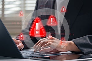Cybersecurity alert warning displayed on laptop screen while businessman types during work. corporate hacking threat, cyberattack