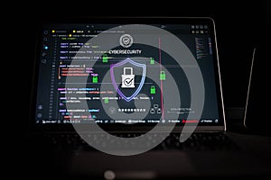 Cybersecurity concept with secure digital shield and lock icon over source code on laptop screen, representing data protection,