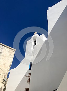 Cycladic Serenity: Whitewashed Church Bell Tower Against the Aegean Blue