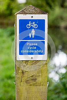 Cycle considerately information sign fitted to wooden poll at wa