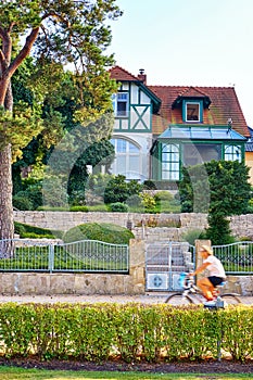 Cycle rider on the beach promenade in Zinnowitz on the island of Usedom. Resort architecture in the background