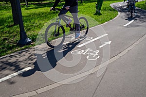 Cycle Walk. Unrecognisable cyclists riding along the cycleway. A winding cycle path with pictograms and signs in a photo