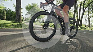 Cycler pedaling along paved driveway on bike outdoors