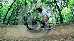 Cycler is riding through a bike trail in the forest