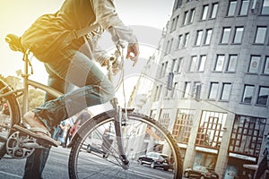 Cycling in the city. Man on bike in traffic with sun-flare.