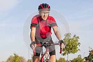 Cycling Concepts and Ideas. Smiling Caucasian Road Cyclist During Ride on Bike Outdoors. Completely Equipped in Professional