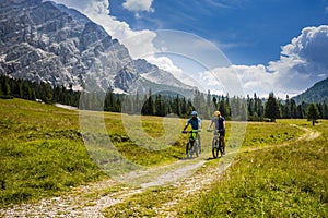Cycling couple with bikes on track, Cortina d`Ampezzo, Dolomites photo