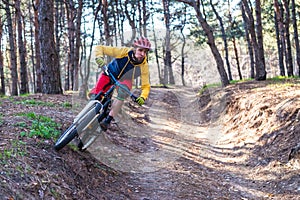 Cycling, a cyclist in bright clothes riding a mountain bike on the edge of the slope. Active lifestyle