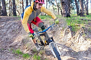 Cycling, a cyclist in bright clothes riding a mountain bike through the woods. Active lifestyle