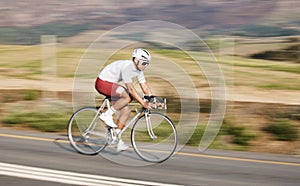 Cycling, fitness and man with bike on road, speed and action with motion blur of cyclist outdoor and helmet for safety