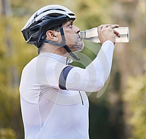 Cycling, fitness and senior man drinking water in park for hydration during training exercise in nature. Bottle, thirsty