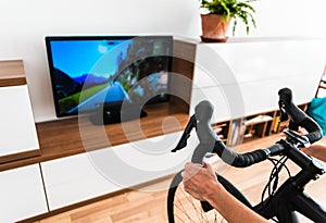 Cycling Indoor with exercise bike trainer motivating himself with the gamification of sport