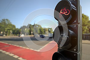 cycling lane traffic light at large inner city junction shows red stop symbol on a bright sunny day with clear blue sky