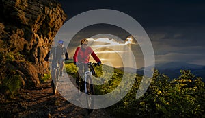 Cycling, mountain biker couple on cycle trail in autumn forest. Mountain biking in autumn landscape forest. Man and woman cycling