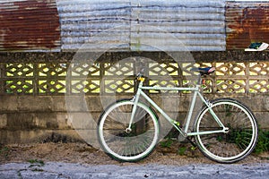 Bike and old fence cement with corrugated iron which as the background.