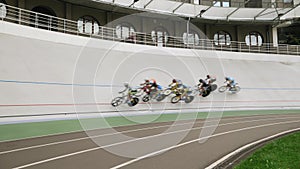 Cycling race on velodrome. Cyclists racing on cycling track, riding bicycles with fixed gear. Professional cycling athletes traini