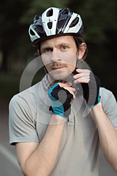 Cycling Safety Concept and Ideas. Portrait of Male Caucasian Cyclist Putting On Helmet. Protective, protection