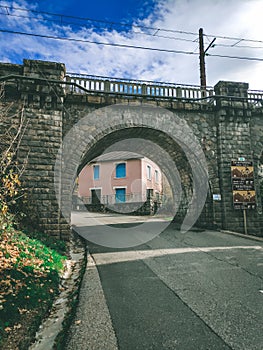 Cycling trail going under an ancient stone bridge.