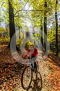 Cycling woman riding on bike in autumn.