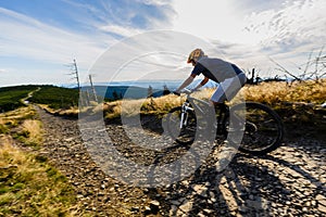 Cycling woman riding on bike in autumn forest landscape. Woman cycling MTB flow trail track. Outdoor sport activity