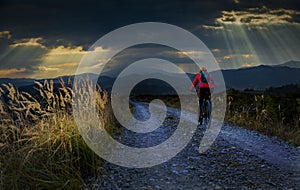 Cycling woman riding on bike in autumn mountains forest landscape. Woman cycling MTB gravel road trail track. Outdoor sport