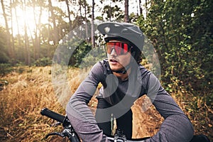 Cyclist, bike and forest on adventure in nature for health, fitness and wellness. Man, bicycle and sunglasses in woods