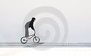 Cyclist bmx against a white wall background. Bmx rider with a bike on a white background