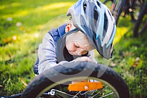 Cyclist boy Bike repair. little boy fixing his bike. Children mechanics, bicycle repair profession. Learning about cycles and