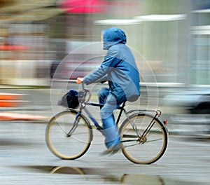 Cyclist on the city roadway in rainy day