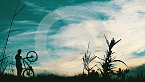 Cyclist climbing mountain at sunset photo