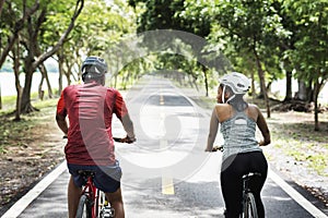 Cyclist couple riding bikes in a park photo