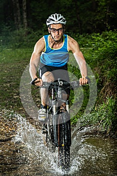 Cyclist driving through a streambed