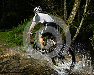 An cyclist is driving through water