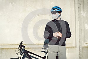 Cyclist in face mask due to smog in the city. Bike courier making a delivery. Man wearing covid 19 coronavirus mask. Cyclist in