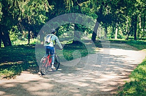 Cyclist in helmet on orange bike riding in park