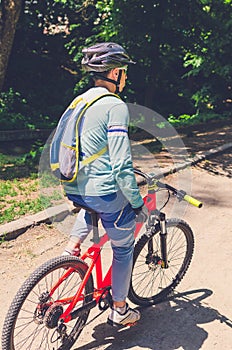 Cyclist in helmet on orange bike riding in park