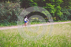 Cyclist in helmet on orange bike riding in park