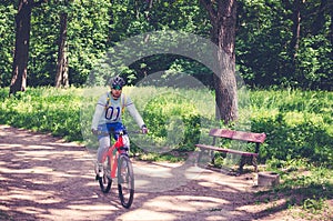 Cyclist in helmet on orange bike riding in park