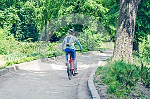 Cyclist in helmet on orange bike riding in park