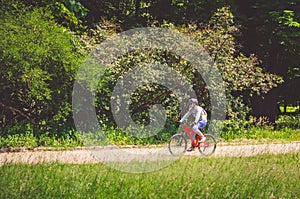 Cyclist in helmet on orange bike riding in park