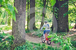 Cyclist in helmet on orange bike riding in park